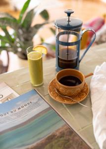 una macchinetta del caffè e una tazza di caffè su un tavolo di Coastal Garden Suite - Kismet Boutique B&B a Serra do Bouro