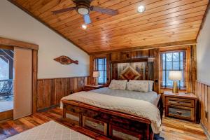 Un dormitorio con una cama en una habitación con paredes de madera. en Rivers Edge at Eagles Nest, en Banner Elk