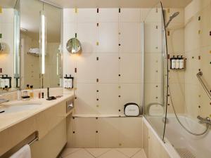 a bathroom with a shower and a sink at Sofitel Golfe d'Ajaccio Thalassa Sea & Spa in Ajaccio