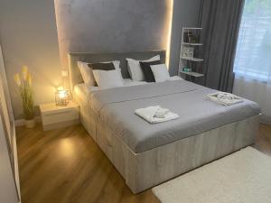 ein Schlafzimmer mit einem großen Bett und weißen Kissen in der Unterkunft M&M Apartments CSV Home in Cluj-Napoca + 36 Fotos