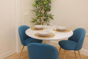 a white table with blue chairs and plates and glasses at SOFIA Suites & Rooms in Pompei