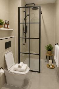 Un baño con inodoro y ducha de cristal. en North London 1-Bed Apt Sleeps 3 10 Min to Tube, en Finchley