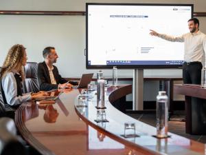 a group of people sitting around a table with a presentation at Mercure Paris CDG Airport & Convention in Roissy-en-France