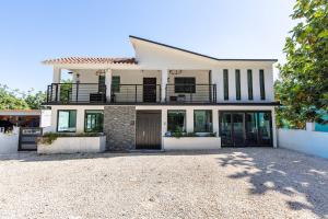 une grande maison blanche avec une grande allée dans l'établissement Dorado White House 6BR Family & Corporate Villa, à Dorado