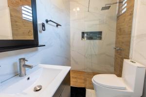 une salle de bain avec un lavabo, des toilettes et une douche dans l'établissement Dorado White House 6BR Family & Corporate Villa, à Dorado 24 autres photos