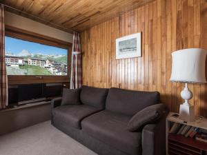 a living room with a couch and a large window at Appartement lumineux avec balcon, accès direct aux pistes à Tignes Le Lavachet - FR-1-502-438 in Tignes