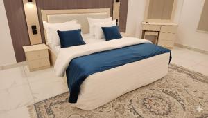 a large bed with blue pillows in a bedroom at النبلاء in Al Madinah