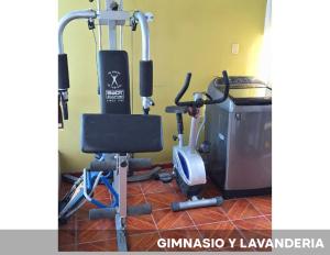 a gym with a treadmill and a chair and a television at Habitaciones en hermosa casa en Yanahuara in Yanahuara