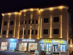 a building with cars parked in front of it at night at النبلاء in Medina