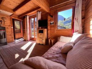 a living room with a couch in a log cabin at Chalet paisible sud, proche pistes et randonnées - FR-1-624-176 in Sixt