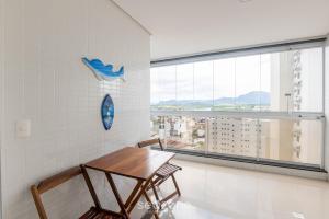 a table and chairs in a room with a window at Apto c/ 2 Quartos a 400 m da Praia INA1306 in Guarapari