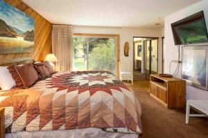 a bedroom with a large bed and a large window at Snowcreek #059 Near Shuttle & Activities in Mammoth Lakes +26 photos