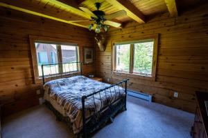 Un dormitorio con una cama en una cabaña de troncos en 5BR Luxurious Mountain Escape, en Forksville
