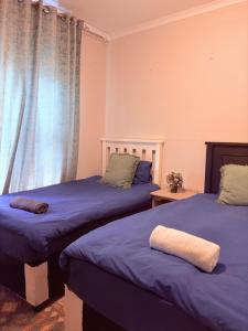 Un dormitorio con dos camas y una ventana. en House For Four Adults, en Witbank