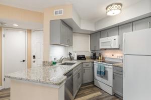 Una cocina con electrodomésticos blancos y un refrigerador blanco. en Peaceful 2Bd 2Bth Pondside Condo - MaryEtta, en Melbourne