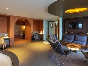 a living room with a blue couch and chairs at IBIS STYLES Rouen Parc Expos Zenith in Saint-Étienne-du-Rouvray