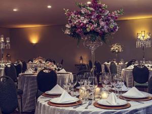 una mesa con un jarrón de flores púrpuras. en Mercure Joinville Prinz, en Joinville 52 fotos más