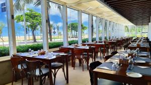 a row of tables in a restaurant with windows at Holiday Inn Fortaleza by IHG in Fortaleza
