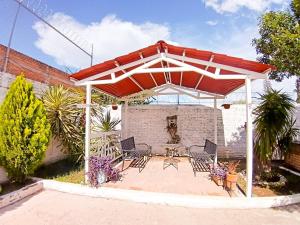 een terras met een rood-witte pergola bij Suite descanso para dos, Paseo Durango in Durango