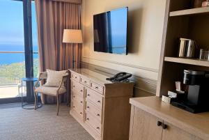 una camera d'albergo con TV e scrivania con sedia di Villa Graziadio Executive Center at Pepperdine University a Malibu