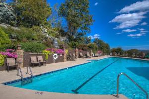 una piscina en un complejo con sillas y flores en Bearfoot Lodge at Echota, en Boone