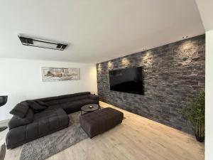 a living room with a couch and a tv on a brick wall at San Nikola in Vrdnik