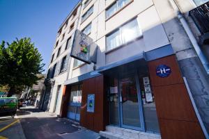 un bâtiment au coin d'une rue dans l'établissement Hôtel Beaulieu, à Clermont-Ferrand