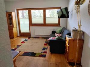a living room with a couch and a tv at Apartment Berg & See in Turracher Hohe