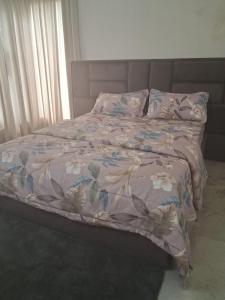 Una cama con una manta y almohadas encima en VB beach Villa at ECR, en Kūvattūr