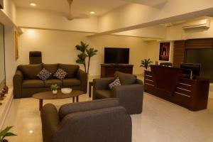 a living room with couches and a flat screen tv at Unique Towers Luxury Boutique Suites in Colombo