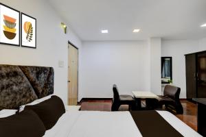 a hotel room with a bed and a table and chairs at Townhouse Oak Q-City Techno Park in Hyderabad