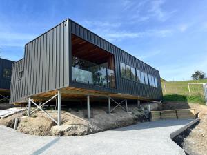 a house with a large window on a hill at Bay View Retreats- Ocean mist in Dover