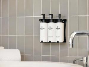 a soap dispenser on a wall in a bathroom at Hotel Sofitel Los Angeles at Beverly Hills in Los Angeles