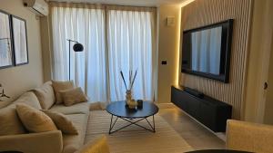 a living room with a couch and a table with a tv at LUUM by Norus in Santiago +41 photos