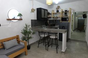 a kitchen with a counter and a bar with stools at Departamento Refugio Sereno cerca de la UAS y nuevo hospital General in Culiacán