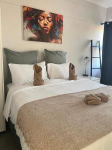 a bedroom with a large bed with a painting on the wall at Ekuku retreat in Oshakati