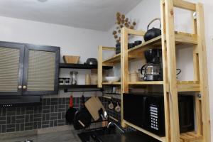 a kitchen with wooden shelves and a microwave at Departamento Refugio Sereno cerca de la UAS y nuevo hospital General in Culiacán +9 photos