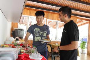 two men standing around a table with a plate of food at KiDRAK OTEL MONTENEGRO-1 in Faralya