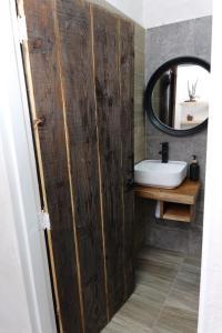 a bathroom with a wooden door next to a sink at Departamento Refugio Sereno cerca de la UAS y nuevo hospital General in Culiacán