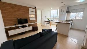 Una sala de estar con un sofá y una cocina. en ASA | Premier Sunset | Piscina | Oktoberfest, en Blumenau