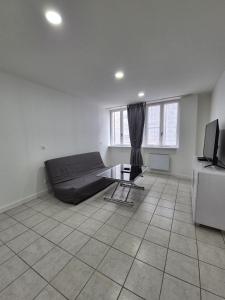 a bedroom with a bed and a table in a room at Le Battant in downtown Besançon in Besançon +3 photos