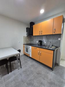 a kitchen with orange cabinets and a table and a sink at Le Battant in downtown Besançon in Besançon