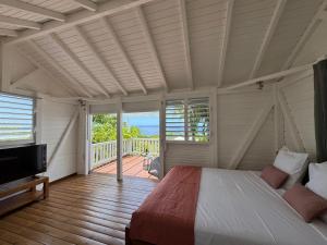 a bedroom with a bed and a balcony at Domaine du Val in Vieux-Habitants