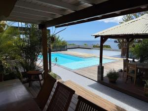 a view of a swimming pool from the deck of a house at Domaine du Val in Vieux-Habitants