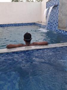 un hombre en una piscina con una fuente en VB beach Villa at ECR, en Kūvattūr
