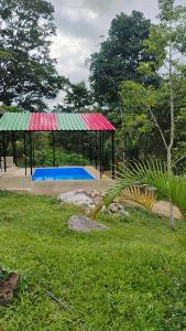 フサガスガにあるQuinta Divina Providenciaの公園にある赤と緑の屋根のパビリオン