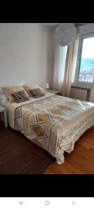 1 cama en un dormitorio blanco con ventana en Vistaalegre, en Zarautz