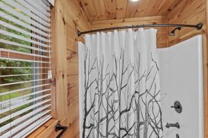 a shower curtain in a bathroom with a window at Among The Trees in Vilas +43 photos
