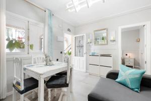 comedor blanco con mesa y sofá en CASA playa 3dormitorios, en Málaga