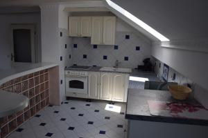 a kitchen with white cabinets and a counter top at Apartment Ivana B in Lesce